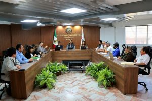 personas sentadas alrededor de una mesa rectángular