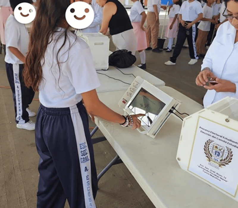 niña usando una pantalla táctil puesta sobre una mesa