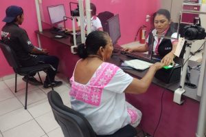 mujer adulta mayor registrando sus huellas dactilares en una maquina