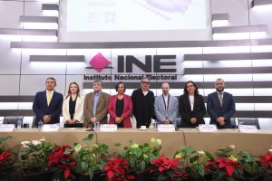 Persona participantes paradas en el estrado del auditorio del Instituto posando para la foto.