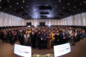 Personas participantes paradas en el salón posando para la foto oficial.