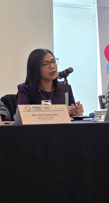 mujer sentada hablando frente a un micrófono