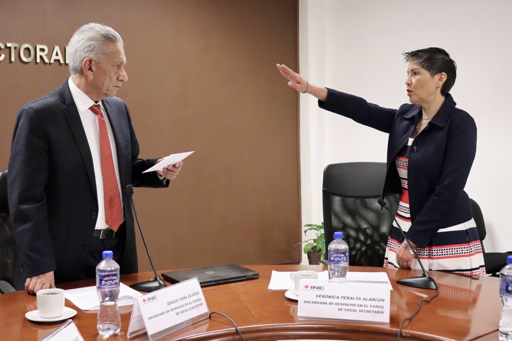 una mujer  de pie con el brazo derecho hacia adelante