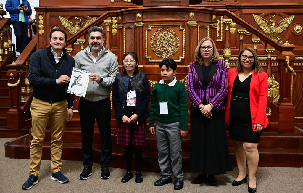 una niña. un niño, dos mujeres, y dos hombres de pie sosteniendo un documento