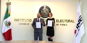 una mujer y un hombre de pie sosteniendo un documento