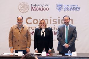 una mujer y dos hombres de pie para foto oficial