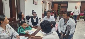 personas adultas sentados alrededor de una mesa platicando