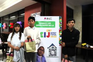 Adolescentes de pie a un lado de un cartel de colores