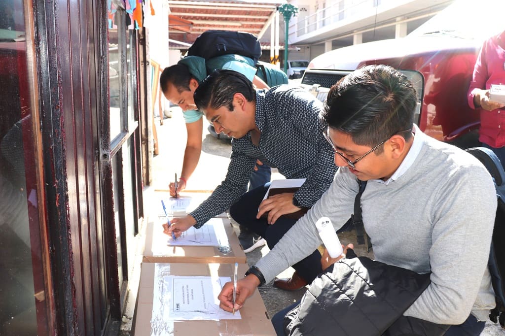 hombres firmando cajas con una hoja blanca pegada