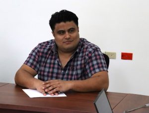 hombre cabello negro camisa a cuadros sentado