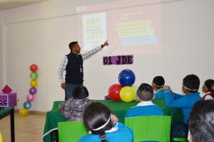 un adulto enseñando a niñas y niños