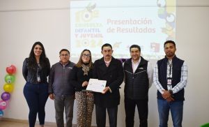 dos mujeres y cuatro hombres de pie sosteniendo un reconocimiento