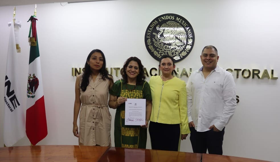 tres mujeres y un hombre de pie mostrando un nombramiento