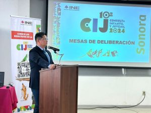 un hombre de pie frente a un atril con micrófono