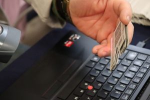 una mano sosteniendo una credencial con corte a un costado