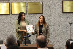 dos mujeres de pie sosteniendo un documento