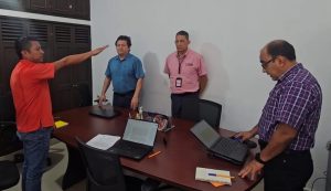 Cuatro hombres de pie, uno de ellos con el brazo derecho al frente