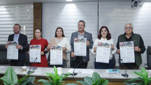 tres mujeres y tres hombres de pie sosteniendo un cartel