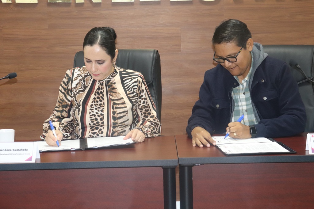 Una mujer y un hombre firman un documento