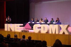 personas en un auditorio hay letras grandes blancas