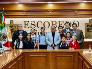 hombres de pie con niñas y niños enfrente