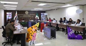 varias personas sentadas alrededor de una mesa con micrófonos