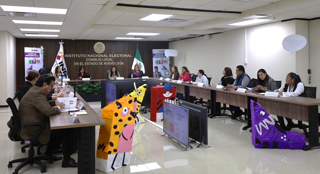 varias personas sentadas alrededor de una mesa con micrófonos