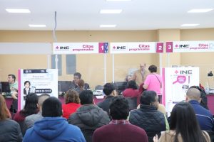 Varias personas sentados en una oficina esperando tramitar su credencial para votar