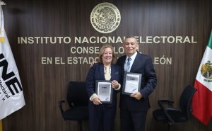 una mujer y un hombre sosteniendo un reconocimiento