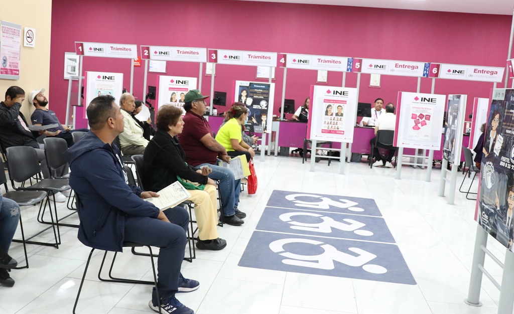 personas sentadas al interior de una oficina pintada de color rosa