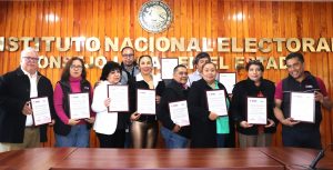 once personas de pie sosteniendo reconocimientos