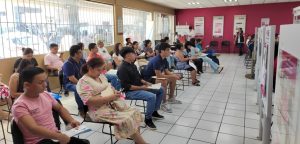 personas sentadas al interior de una oficina color rosa