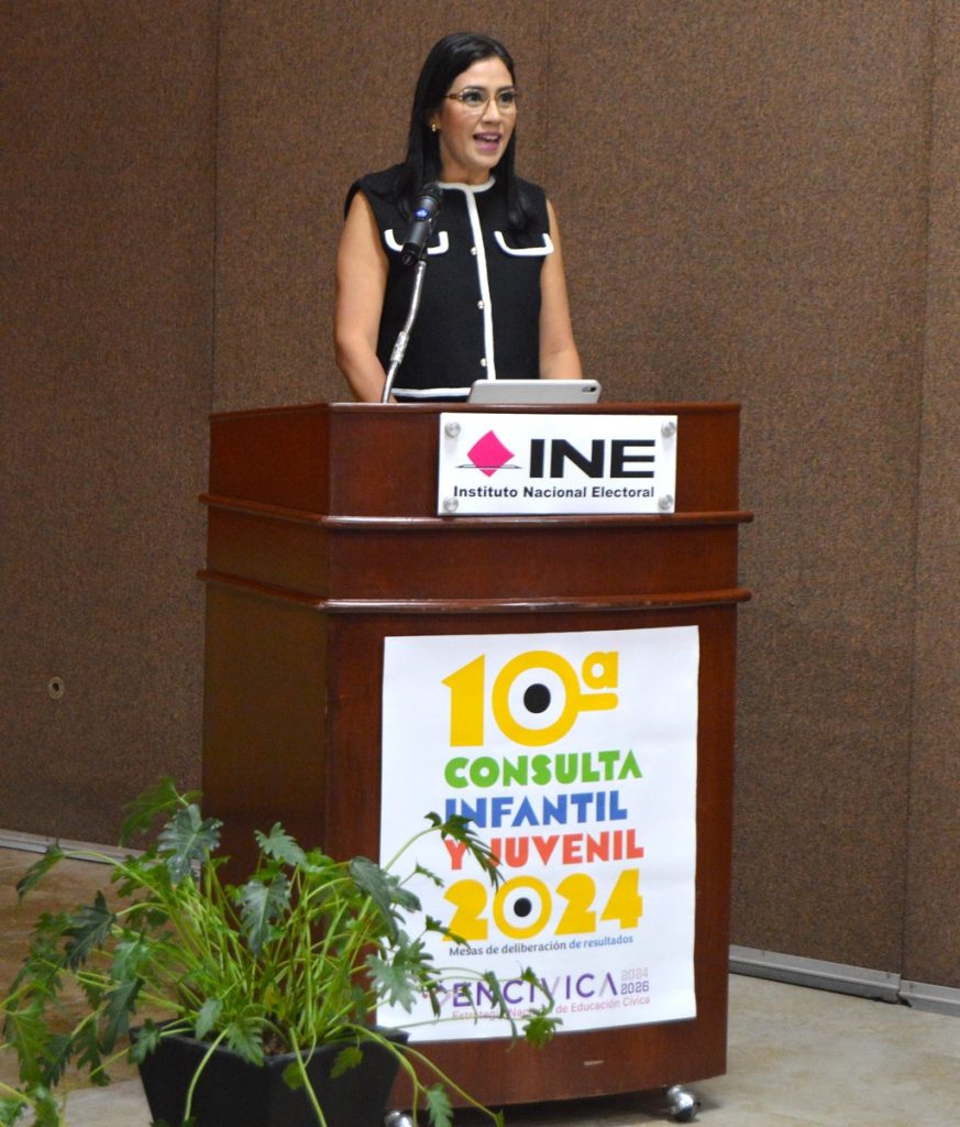 Mujer de pie, frente a un atril con micrófono