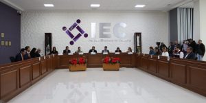 salón con muebles de madera y las letras en plateado IEC
