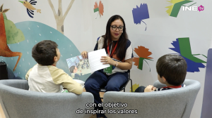 Mujer mostrando un libro a dos niños