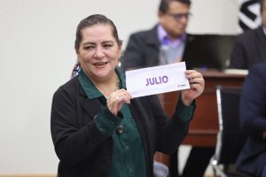 Consejera presidenta,Guadalupe Taddei sosteniendo papeleta con el mes de julio
