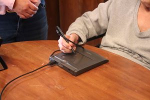 persona realizando su firma en tableta digital