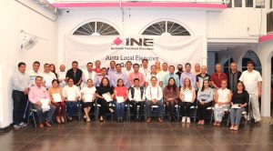 mujeres y hombres de pie y sentados, sostienen reconocimientos