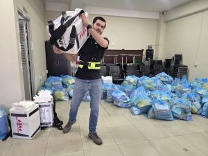 un hombre cargando una caja blanca con letras rosas