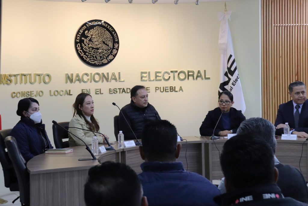 cinco personas sentadas frente a una mesa con micrófonos