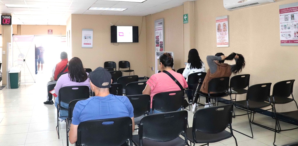 personas sentadas en sillas negras dentro de una oficina
