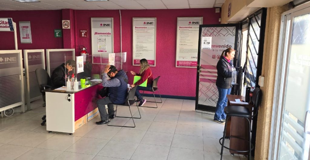 personas dentro de una oficina con paredes rosas
