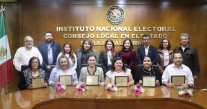 personas de pie y sentadas sosteniendo un reconocimiento