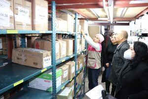 personas observando unas cajas colocadas en un mueble