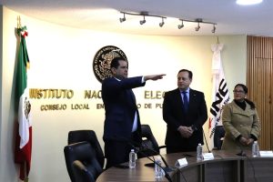 hombre de pie con el brazo derecho extendido hacia el frente.