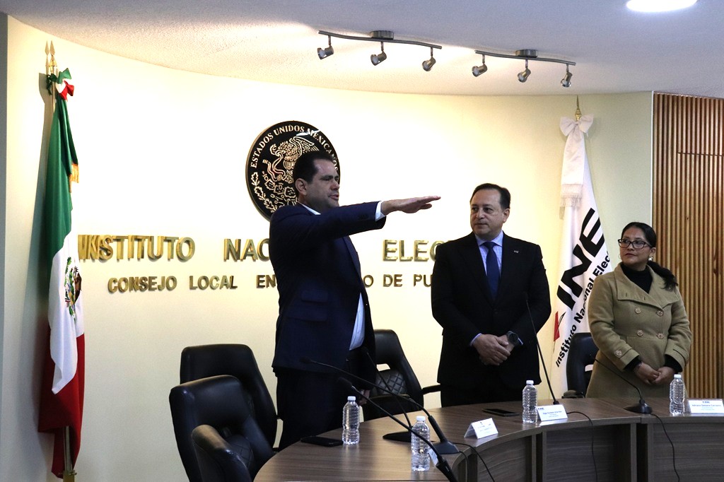 hombre de pie con el brazo derecho extendido hacia el frente.