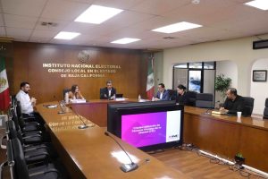 personas sentadas alrededor de una mesa con micrófonos