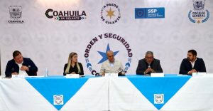 personas sentadas frente a un mesa con mantel blanco y azul