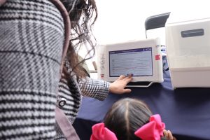 una mujer y una niña frente a una Urna Electrónica del INE en Guanajuato