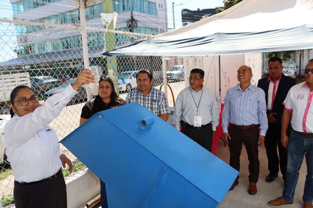 Una mujer colocando credenciales para votar sin validez en maquina trituradora